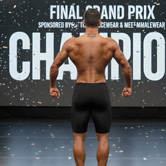 A muscular man shows the back side of metroMaleWear MetroMuscleWear cafe physique board short 4716-19 in black