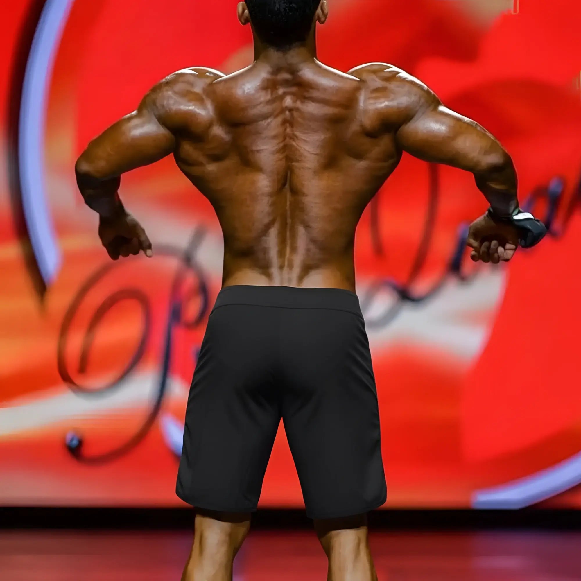 Back view of metro malewear metaphysiquewear ifbb pro mens physique board shorts showcasing muscular back