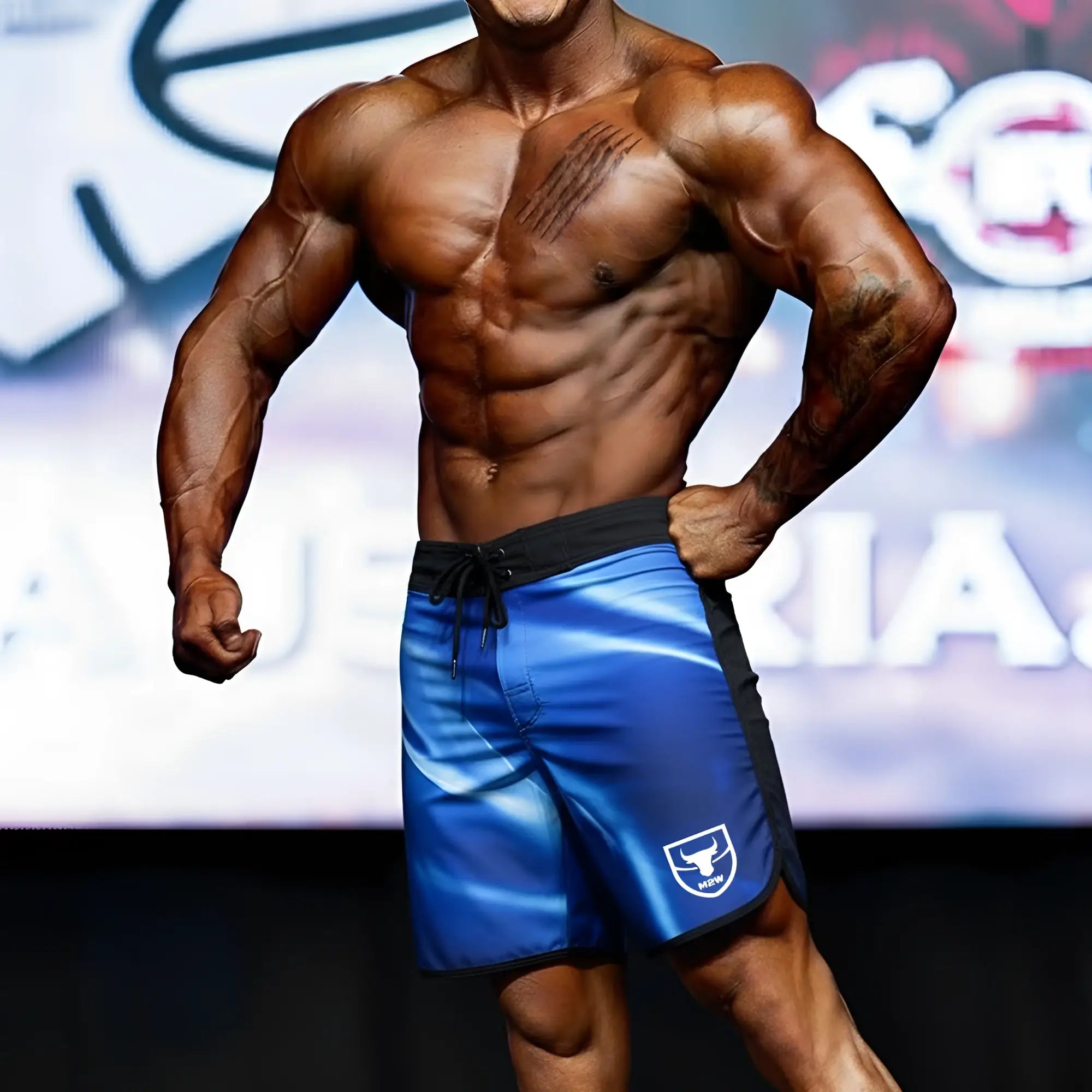 Blue athletic board shorts with black trim and white logo on lower left leg by metromalewear for mens physique
