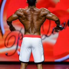 White metro MuscleWear IFBB Pro mens physique board shorts with red waistband and black trim designed for performance
