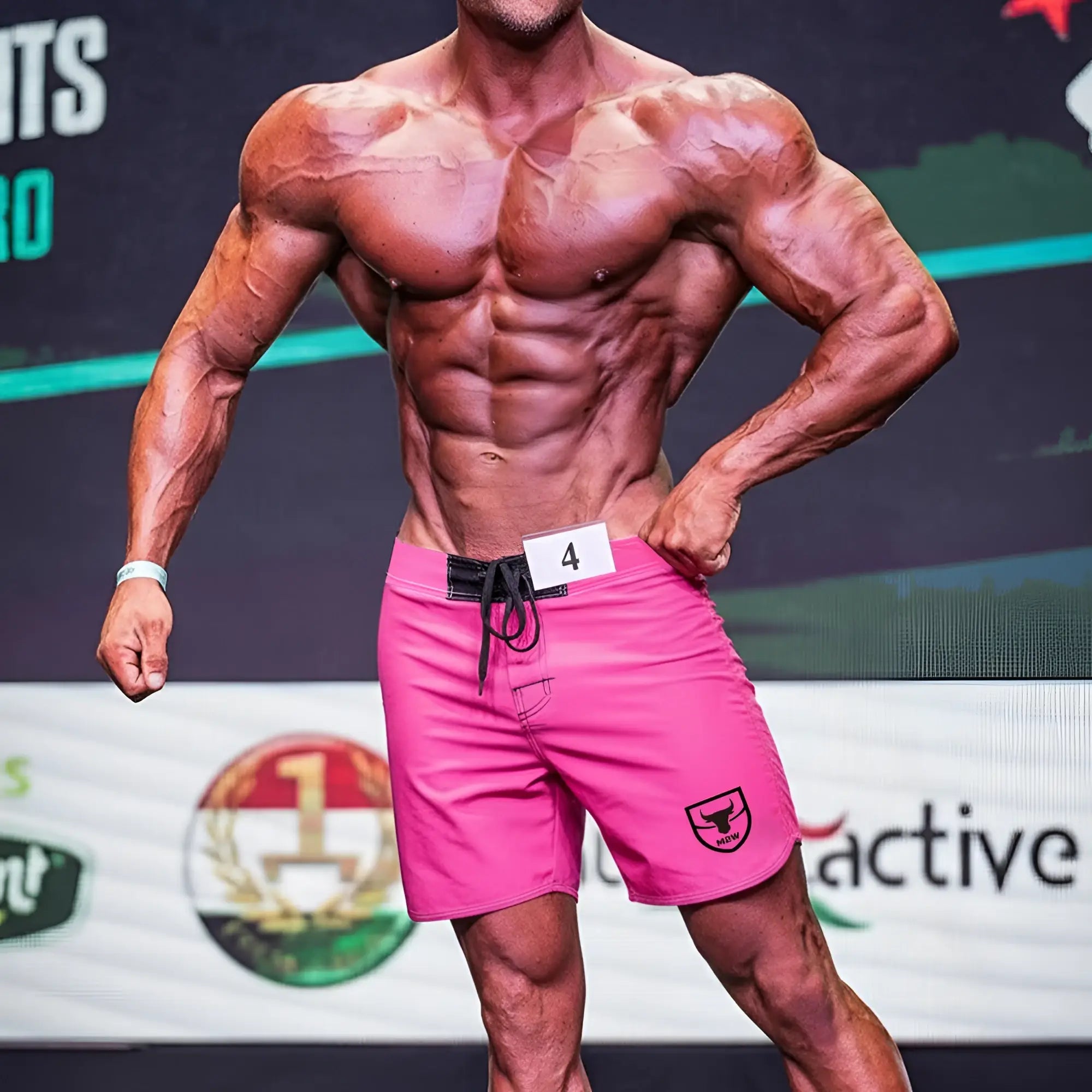 MetroMaleWear Physique bright pink athletic shorts with black drawstring waistband and shield logo on lower right leg