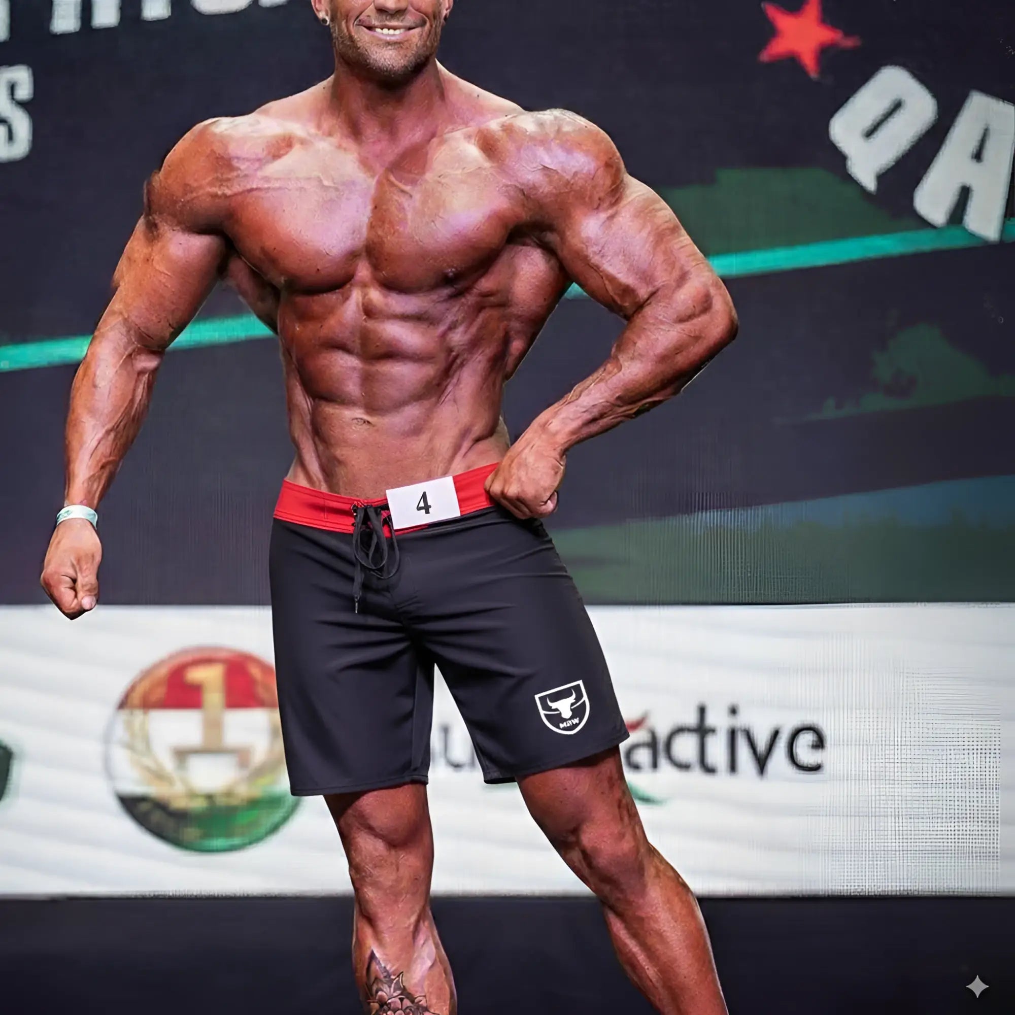 Black athletic MetroMaleWear physique board shorts with red waistband and white logo on left leg for activewear use