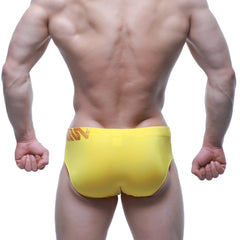 Bright yellow MetroMaleWear Rubio swim brief with subtle orange logo on waistband in athletic stretch fabric