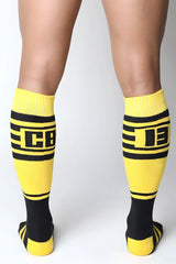Bright yellow and black midfield knee high socks with bold horizontal stripes and a prominent cb logo center