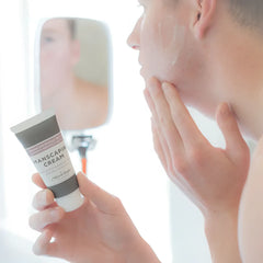 A sleek matte gray tube of vichy cologne mixologie manscaping cream shave lotion sent iv with white cap and minimalist label