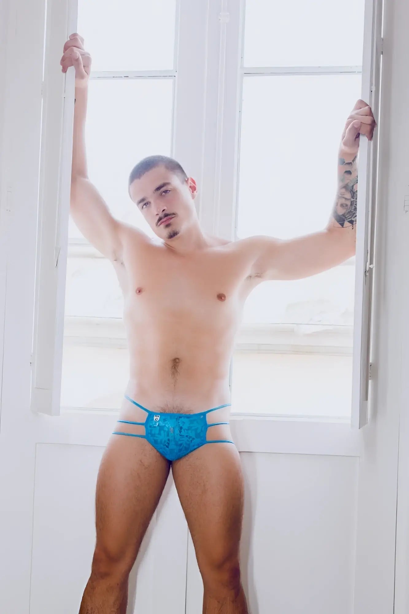 Mob men’s lace pouch thong in blue lace trimmed briefs with subtle pattern and thin side straps shown from the back
