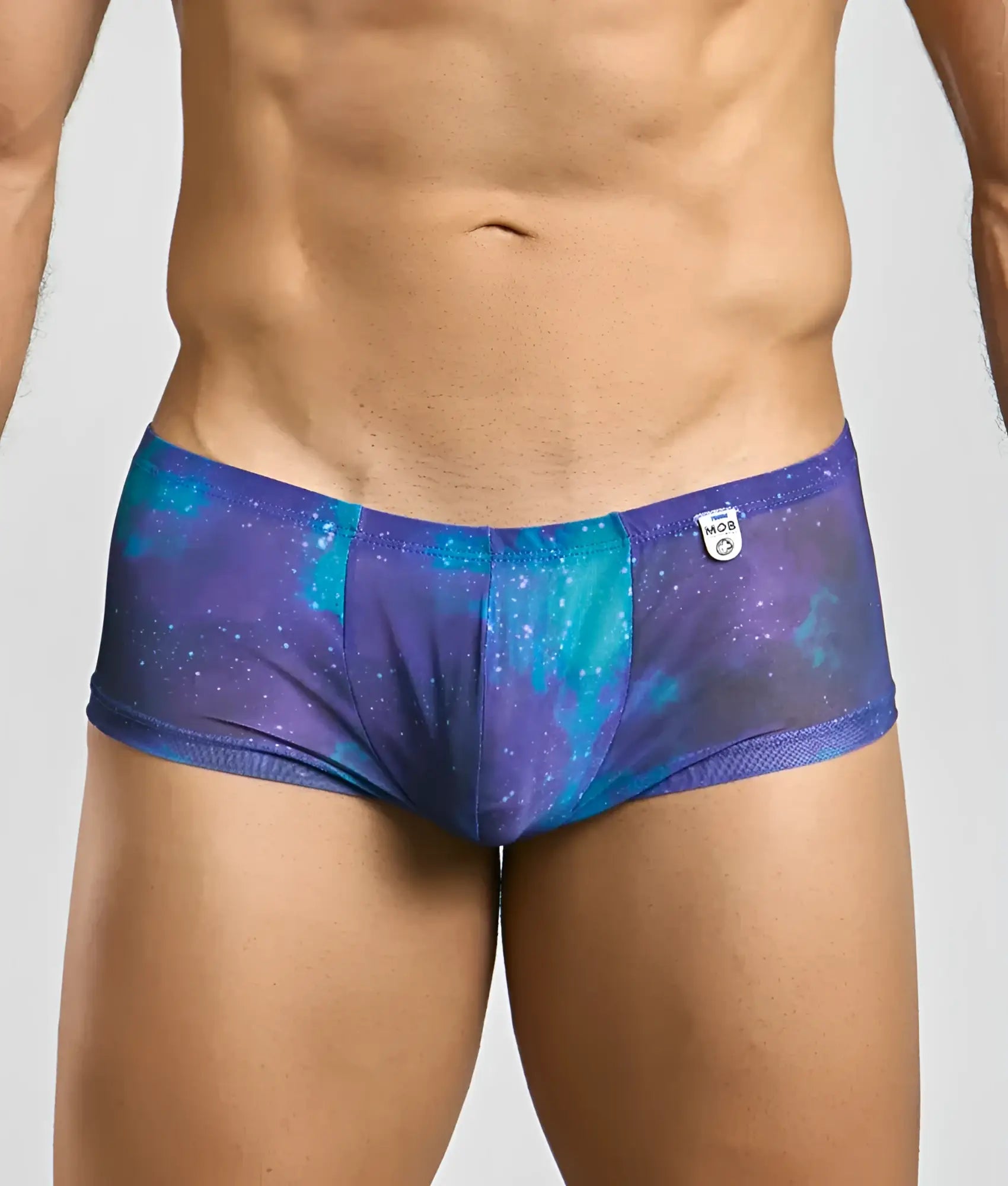 Mob men’s sexy sheer hip brief in purple and teal galaxy pattern with mesh trim made of sheer fabric