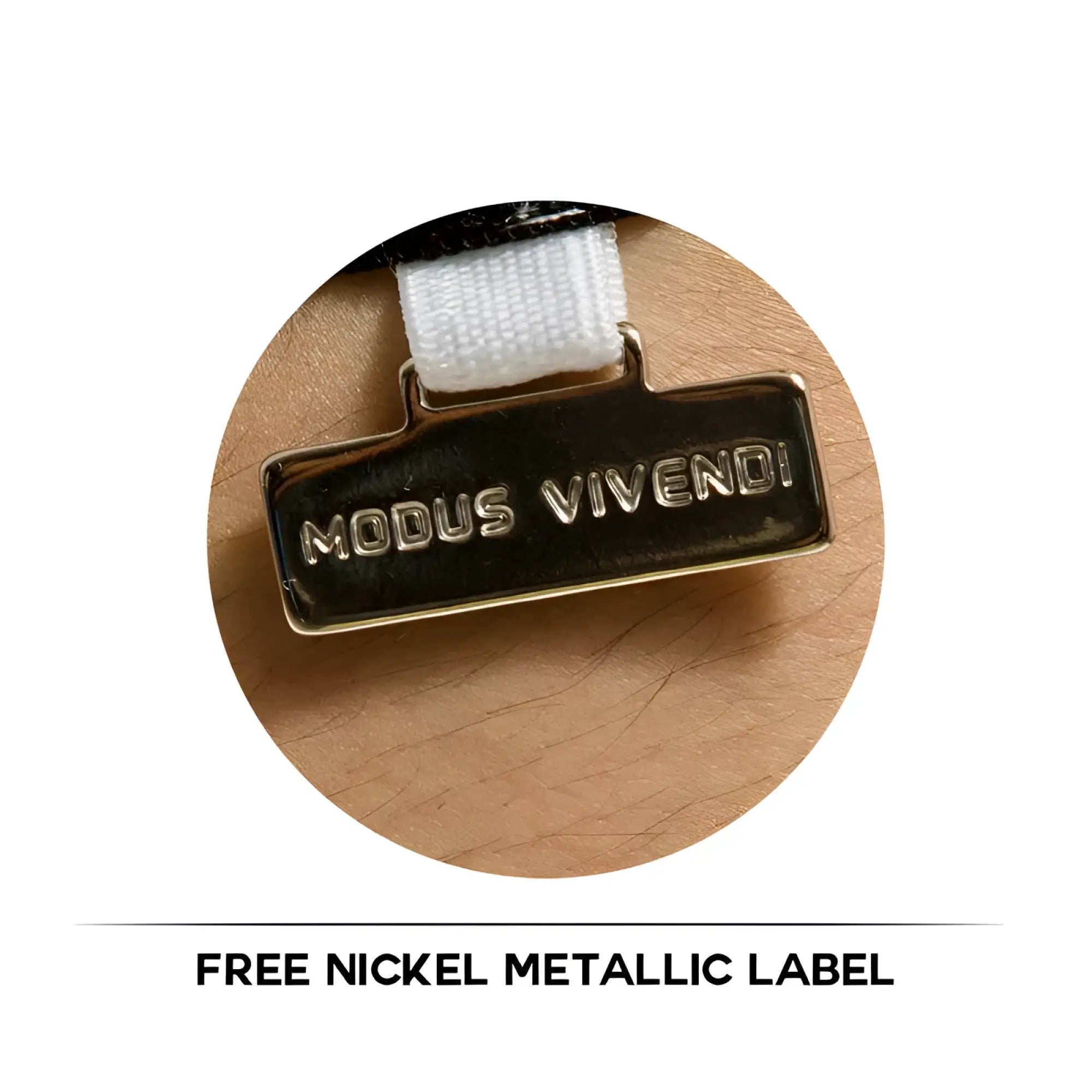 A metallic label with raised silver lettering attached to a white strap on modus vivendi satin short robe size l