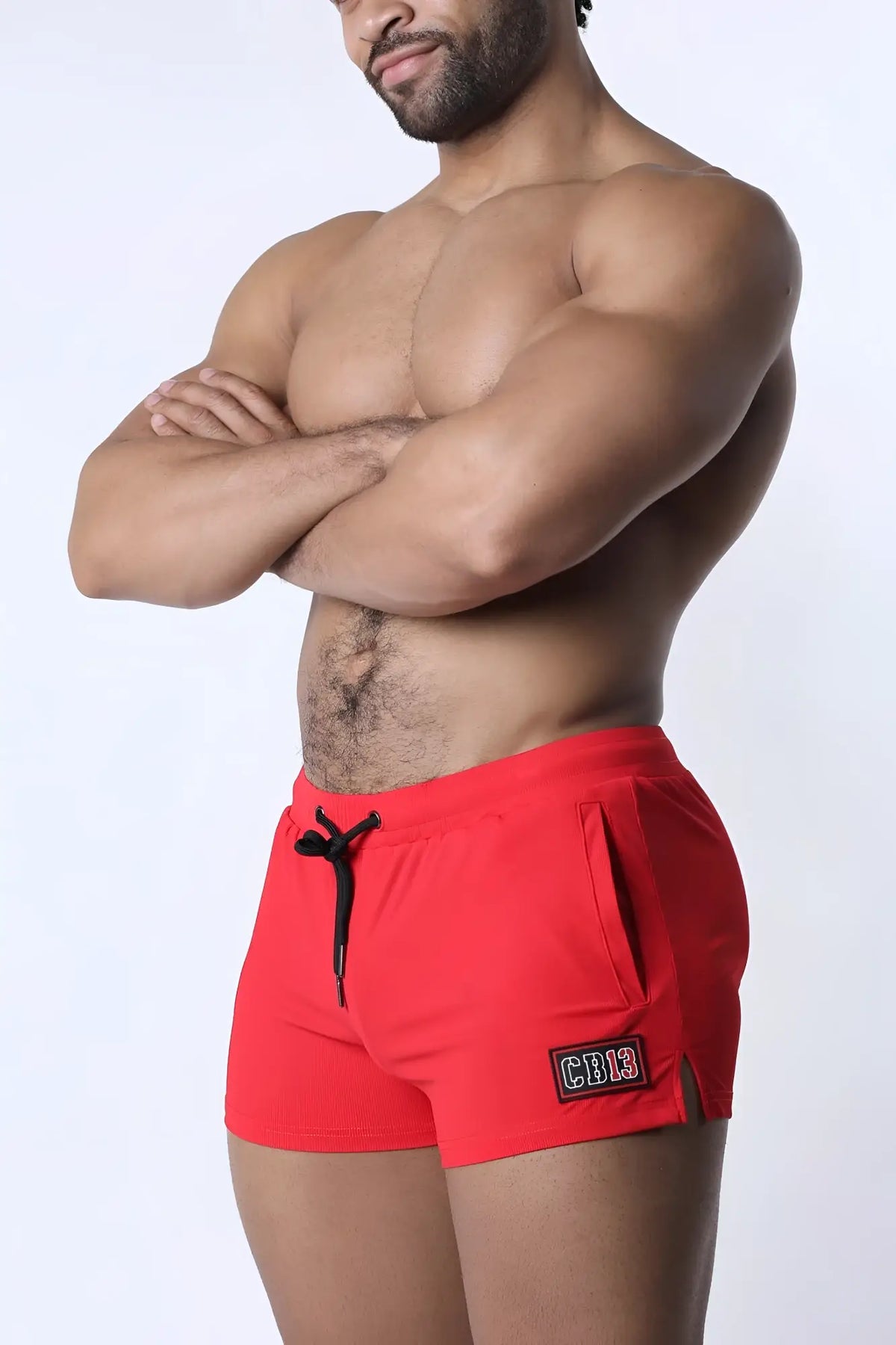 Red muzzle up athletic shorts with black drawstring and side rectangular patch designed for active wear