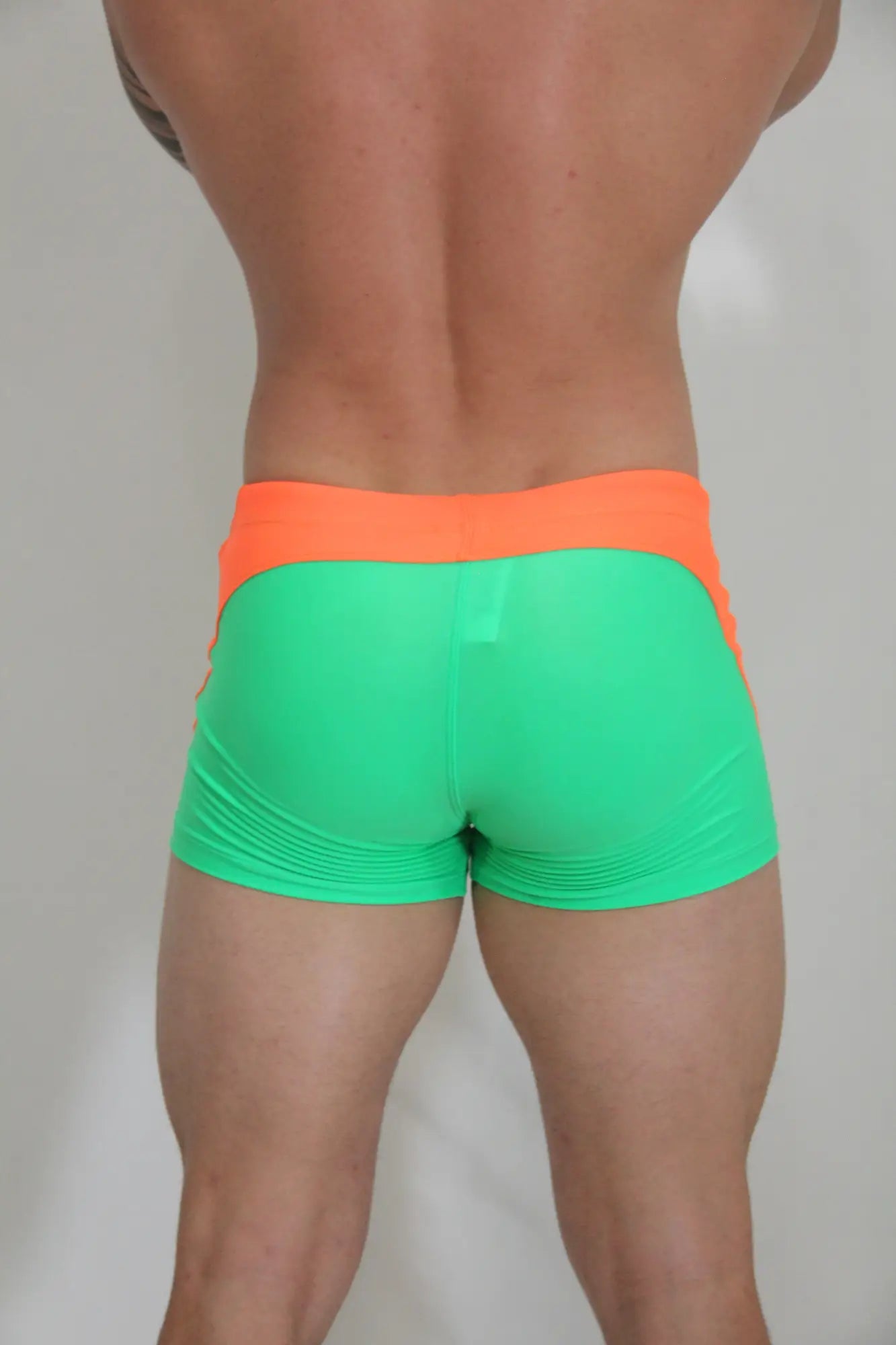 Neon curved sq cut trunk vibrant neon green and orange snug athletic shorts designed for performance and comfort