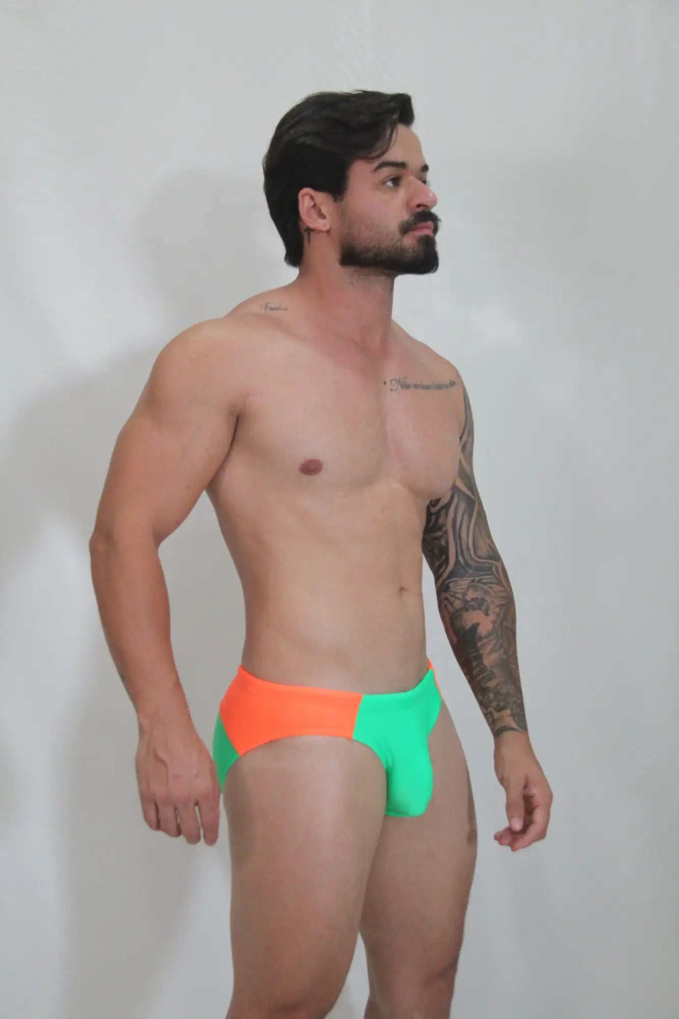 Neon curved swim brief with vibrant two-tone neon orange and electric green colors in a sleek modern cut