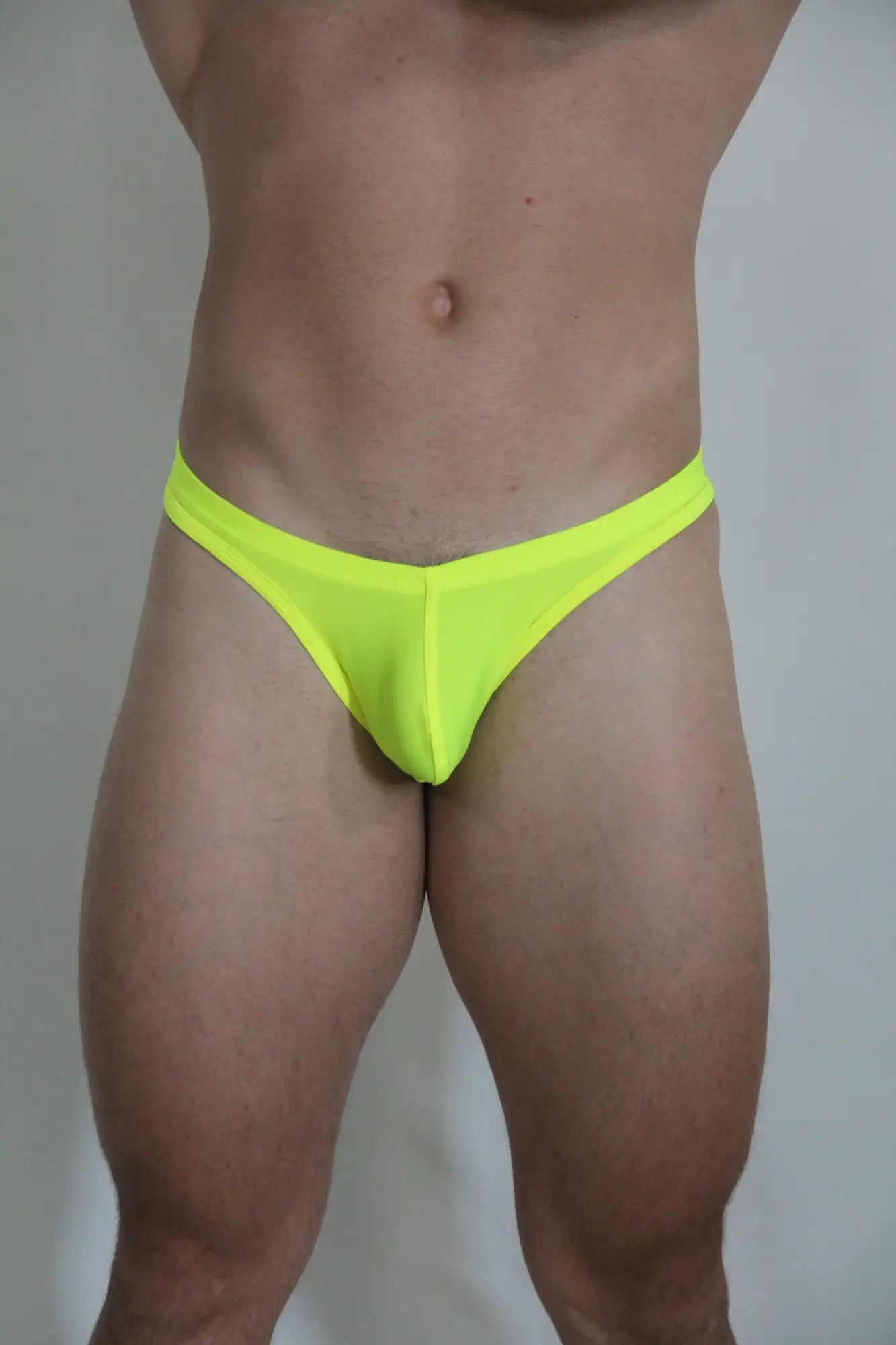 Neon yellow swim thong briefs made of stretchy material shown from the back available in four colors