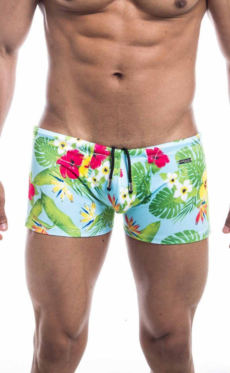 Oceanico square cut swim trunks in light blue with green leaves and pink red yellow tropical floral print