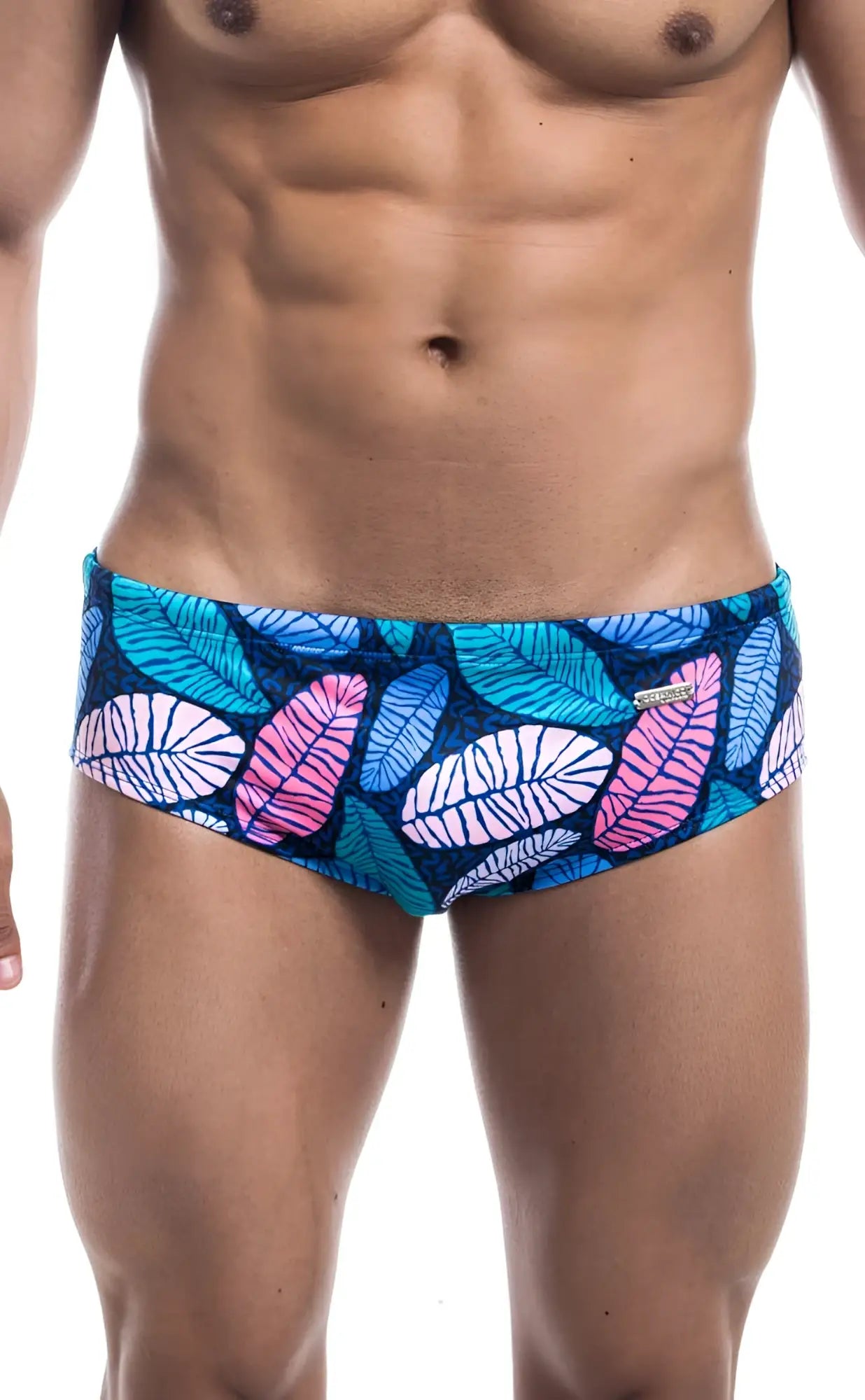Oceanico swim brief featuring vibrant tropical leaf-patterned swim trunks in teal pink white on dark blue base