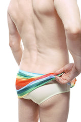 PetitQ loincloth brief rainbow mesh swim trunks with beige base and vibrant rainbow-striped horizontal bands