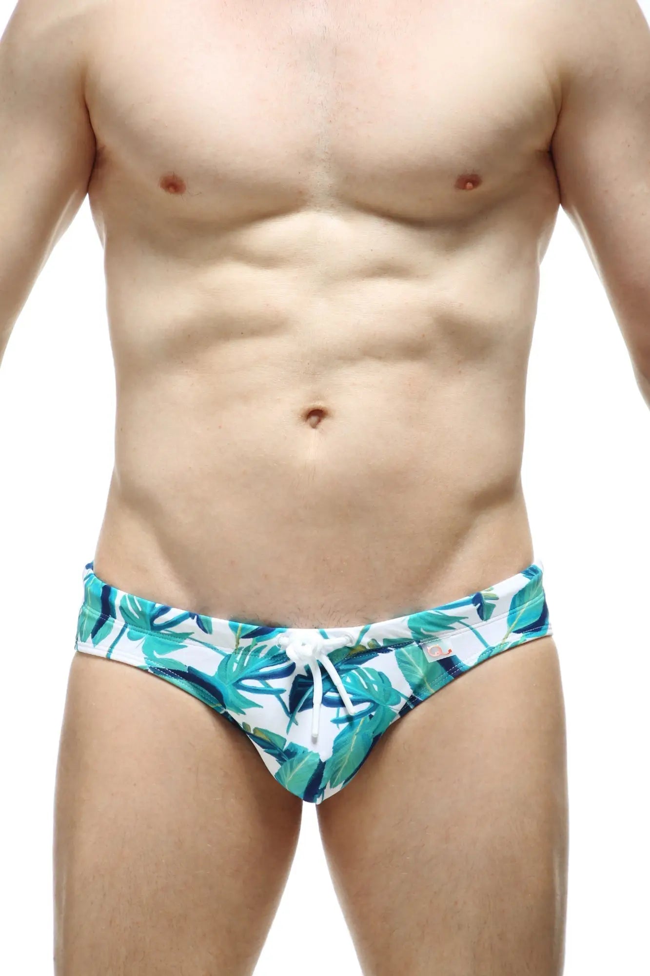 White swim trunks petitq swim bikini macouba with vibrant teal and green tropical leaf pattern and white drawstring waistband