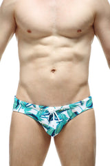 White swim trunks petitq swim bikini macouba with vibrant teal and green tropical leaf pattern and white drawstring waistband