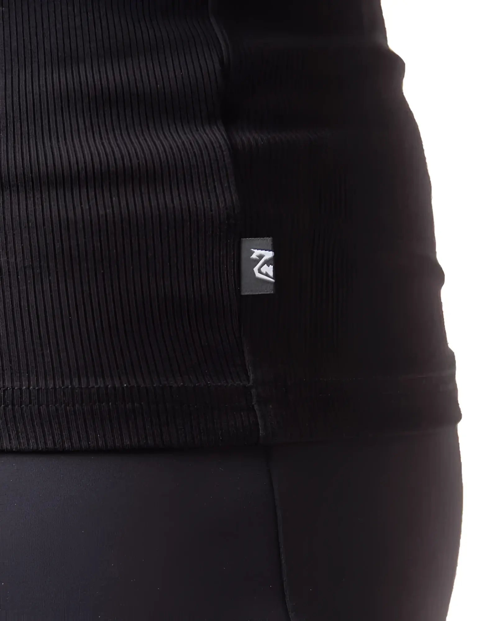 Black ribbed knit pig rib tank top with small rectangular brand tag on the seam showing front side details