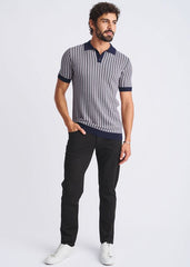 A man wearing a textured stripes silk tencel polo shirt in navy and gray with a dark blue collar cuffs and hem