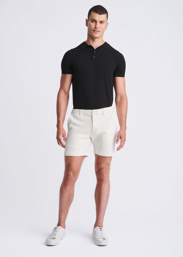 A pair of crisp white textured stretch knit chino shorts with a tailored fit and belt loops