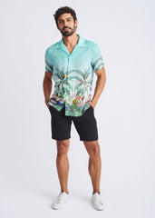 A men’s short-sleeved modal shirt in vibrant turquoise with tropical border print featuring foliage and colorful birds