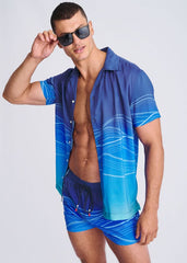 Blue gradient short-sleeved shirt with white wavy line pattern matching waves print swim shorts with mesh lining
