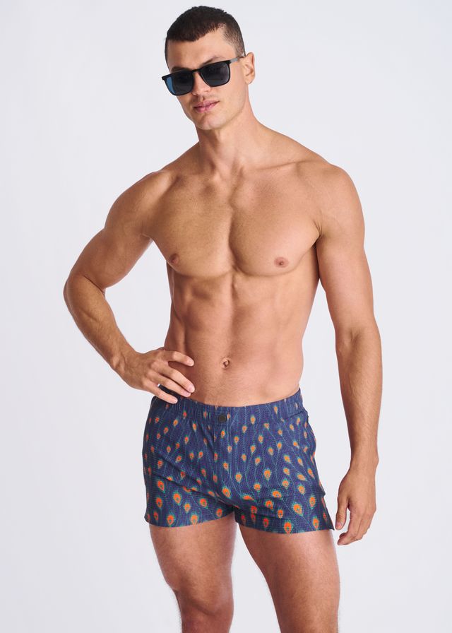 Blue seersucker swim shorts with mesh lining featuring orange and yellow peacock feather patterns