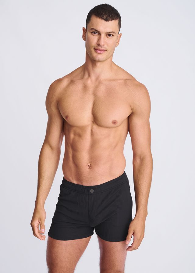 Black seersucker swim shorts with mesh lining featuring a sleek minimalist design and single button waistband closure