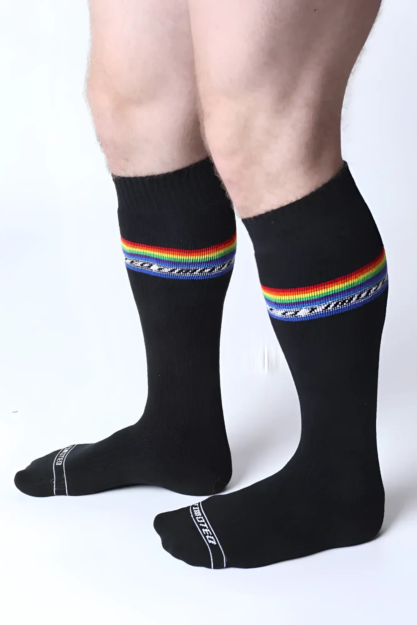 Black pride knee high socks with vibrant rainbow stripe decorative blue pattern and white text on the toe area