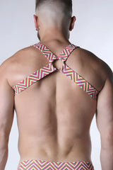 A man wearing the back side of a red white and green zigzag pattern pulse elastic harness with crossed shoulder straps
