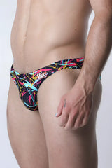 Vaux pulse swim brief men’s swim trunks with bold neon pink yellow and cyan abstract lines on black background