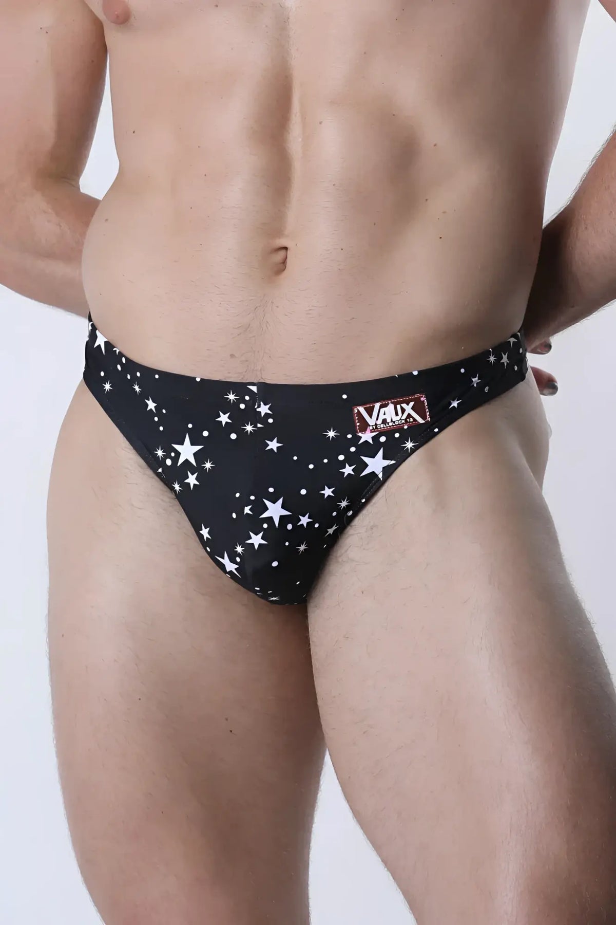 Black men’s briefs with star pattern and red vaux label on waistband from pulse swim thong collection
