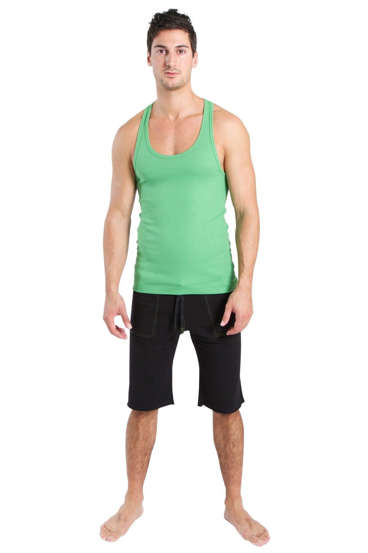 A man wearing a bamboo green racerback yoga tank top with a rounded neckline and black shorts with side pockets