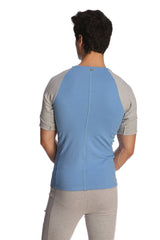 Back view of light blue and gray raglan sleeve athletic shirt with subtle vertical seam in raglan virtual crew neck style