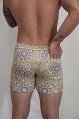 Rainbow kaleidoscope linen texture shorts featuring vibrant multicolored geometric mosaic pattern swim trunks