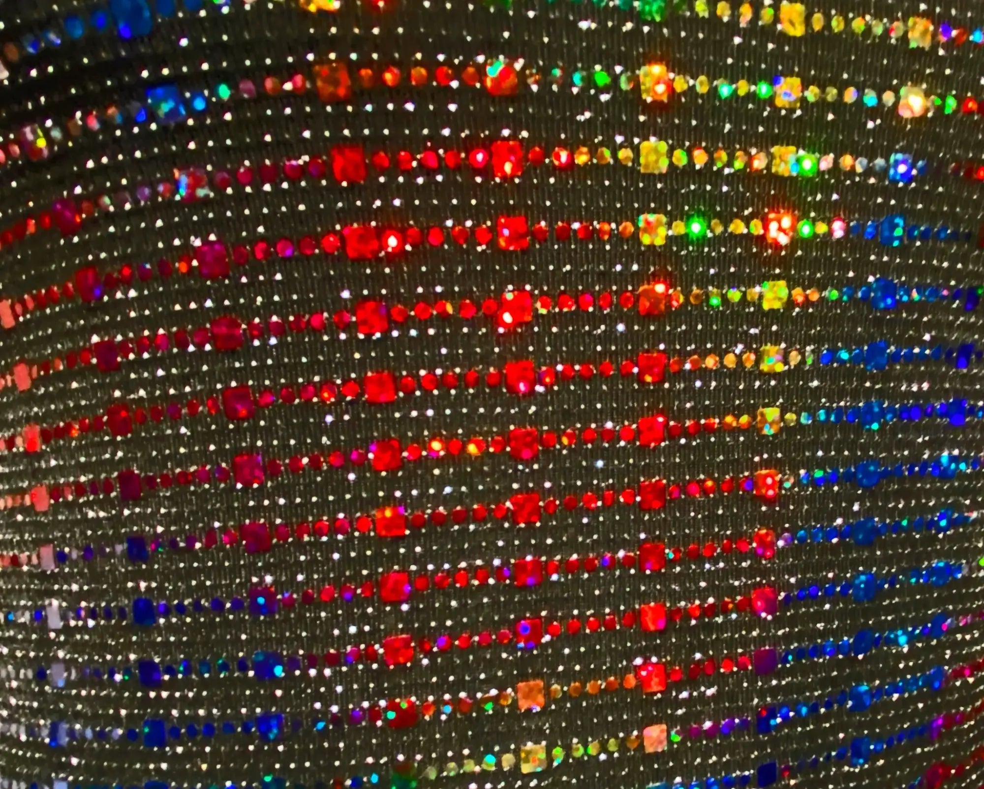 Rainbow sequin tank featuring shimmering black fabric with vibrant rainbow-colored rhinestones in diagonal rows