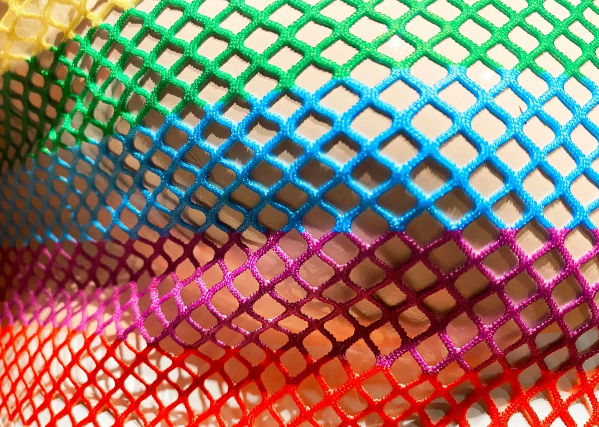 A vibrant rainbow stripe fine mesh tee featuring diamond-shaped pattern in colorful mesh netting