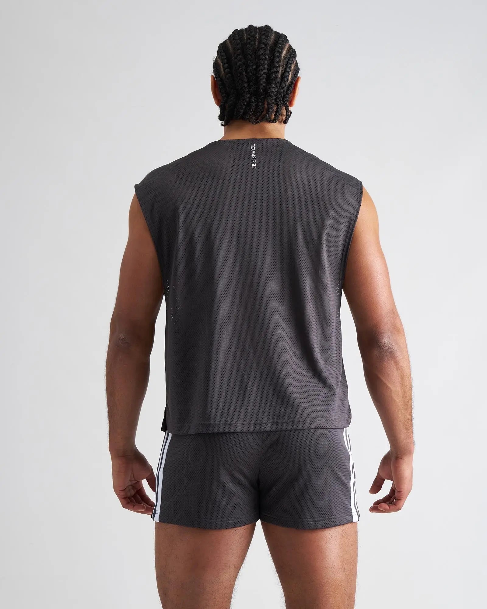 Dark gray mesh sleeveless s.s.c. muscle tank with subtle vertical logo on the back side for athletic use