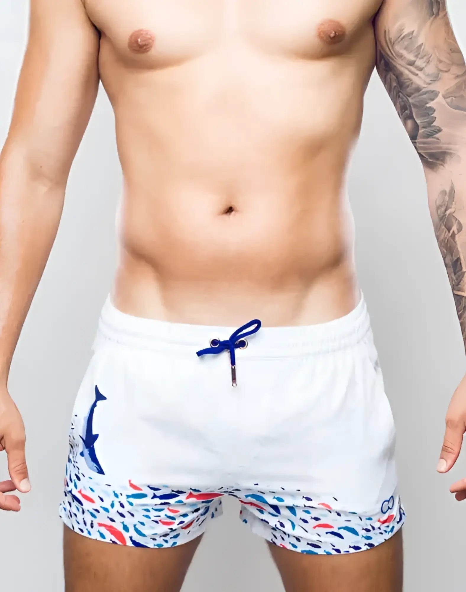 White s50 seascape print swim short featuring blue whale graphic and colorful fish pattern with navy drawstrings
