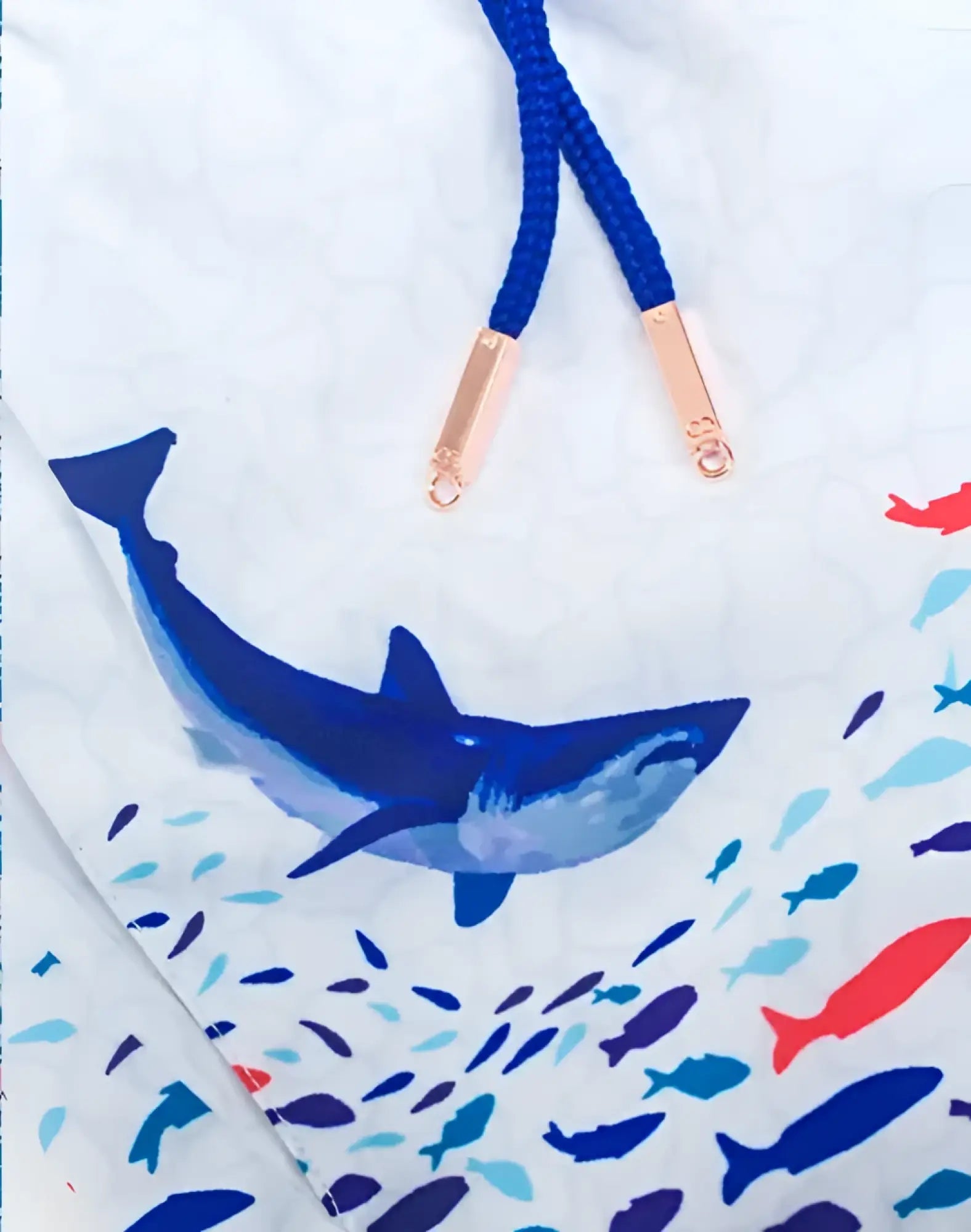 White s50 seascape print swim short with bold blue shark and colorful fish print navy drawstrings and rose gold tips