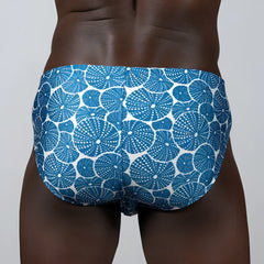 Blue and white patterned swim trunks featuring a repeating sea urchin dotted motif for casual beachwear