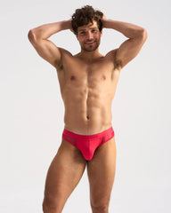 Bright red mesh-textured men’s briefs with sleek modern design and subtle brand logo on the waistband from SCORE SHEER JOCK