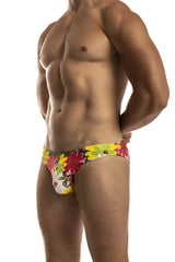 Vibrant floral-patterned men’s second skin swimsuit swim trunks in red yellow and green on a white base