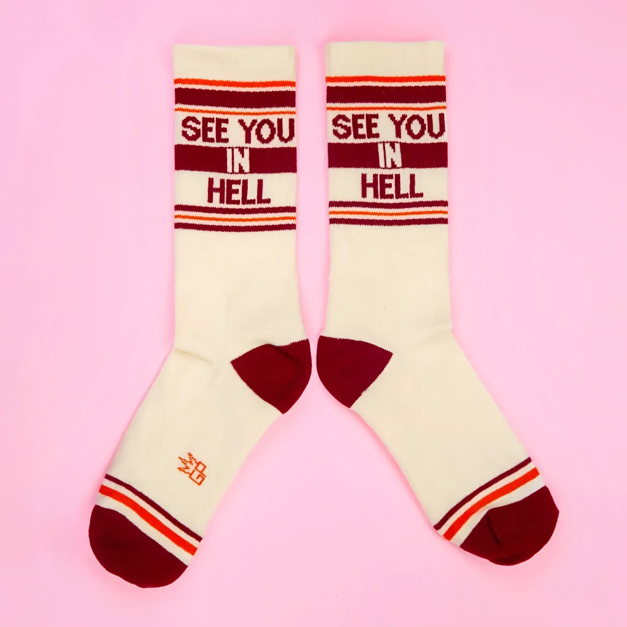 See you in hell crew socks cream-colored with maroon and orange stripes and bold red lettering on top