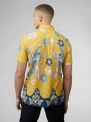 A vibrant yellow short-sleeved shirt with signature abstract botanical print featuring blue pink floral and bird motifs
