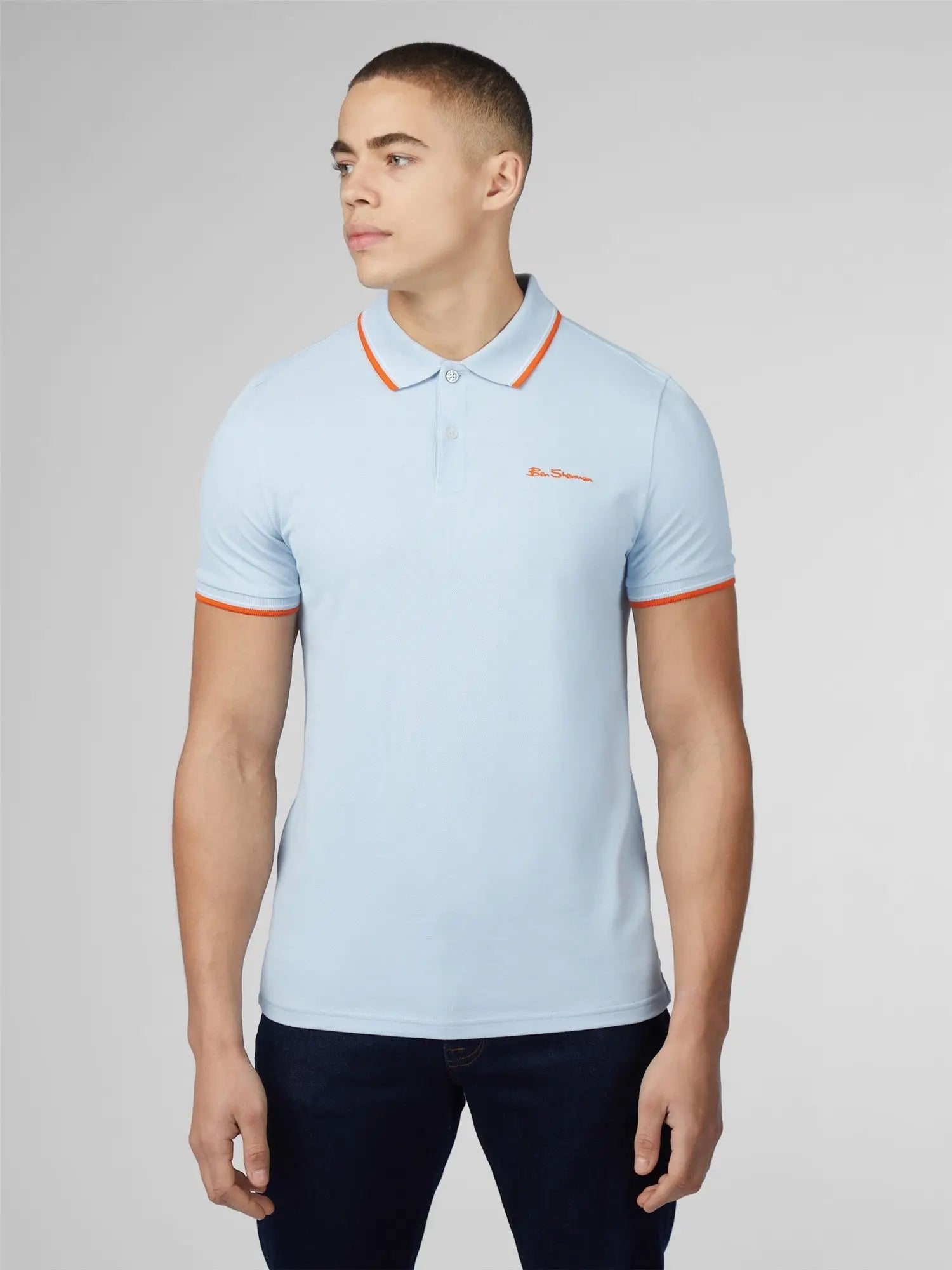 Light blue signature polo shirt with orange collar and cuff trim and small embroidered chest logo