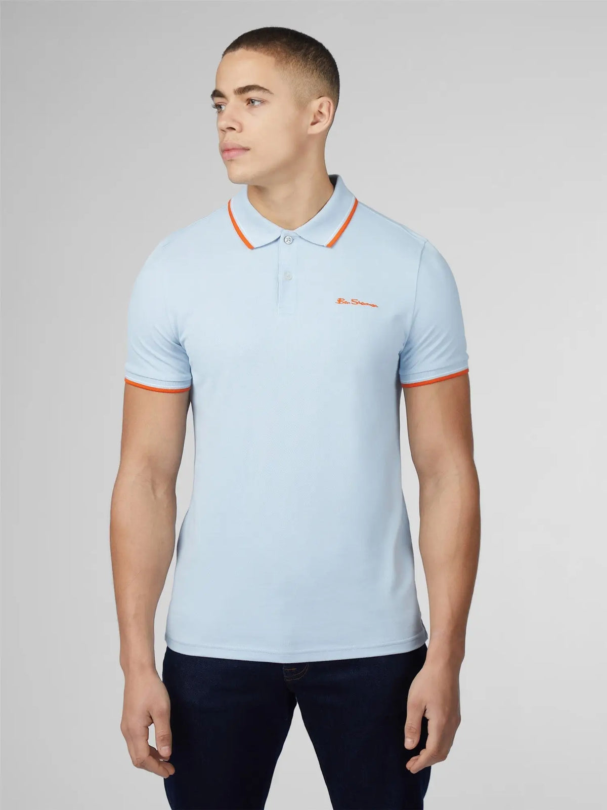 Light blue signature polo shirt with orange collar and cuff trim and small embroidered chest logo