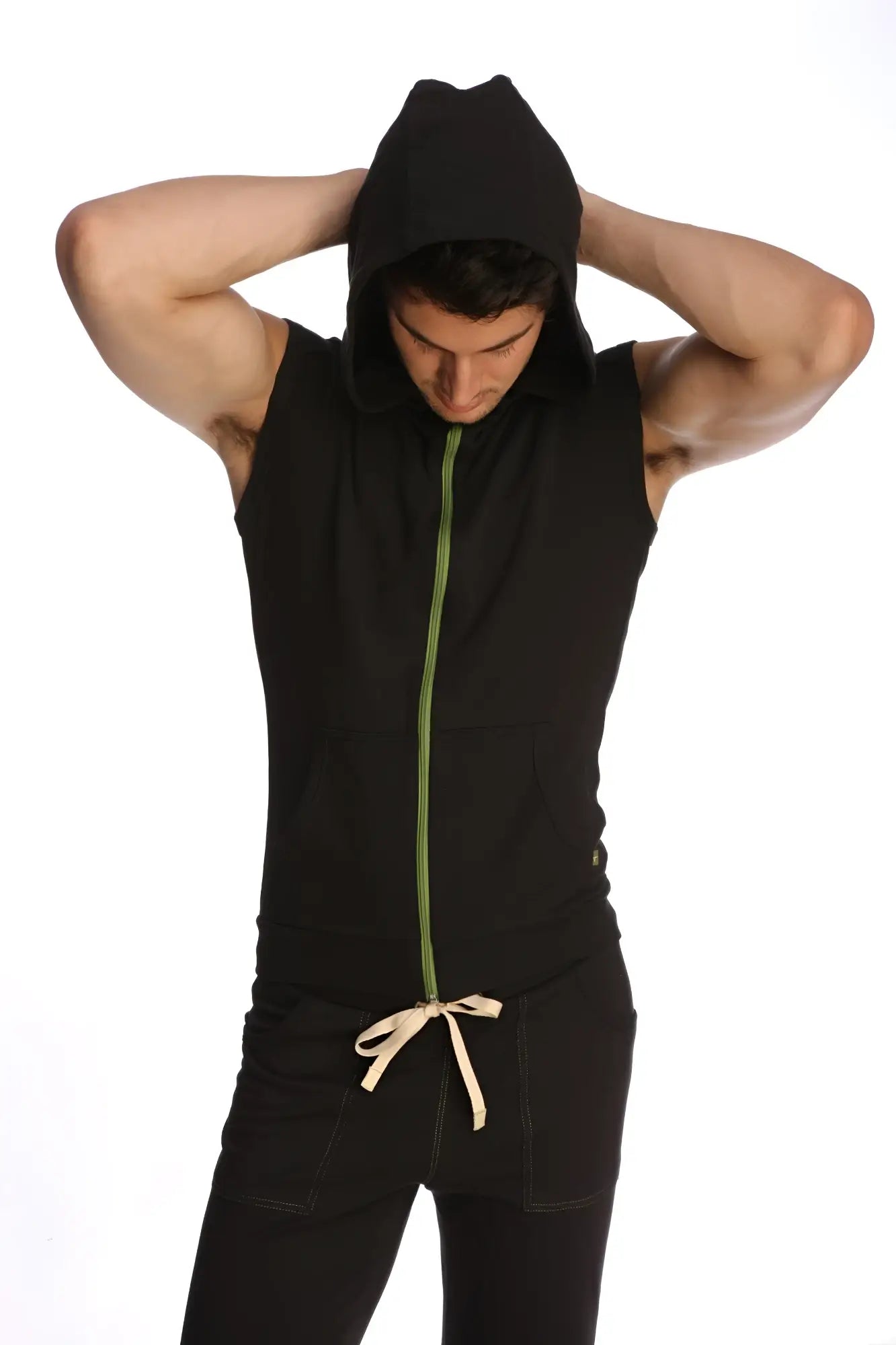 Sleeveless yoga hoodie in black with green zipper and beige drawstring at the waist for comfortable activewear
