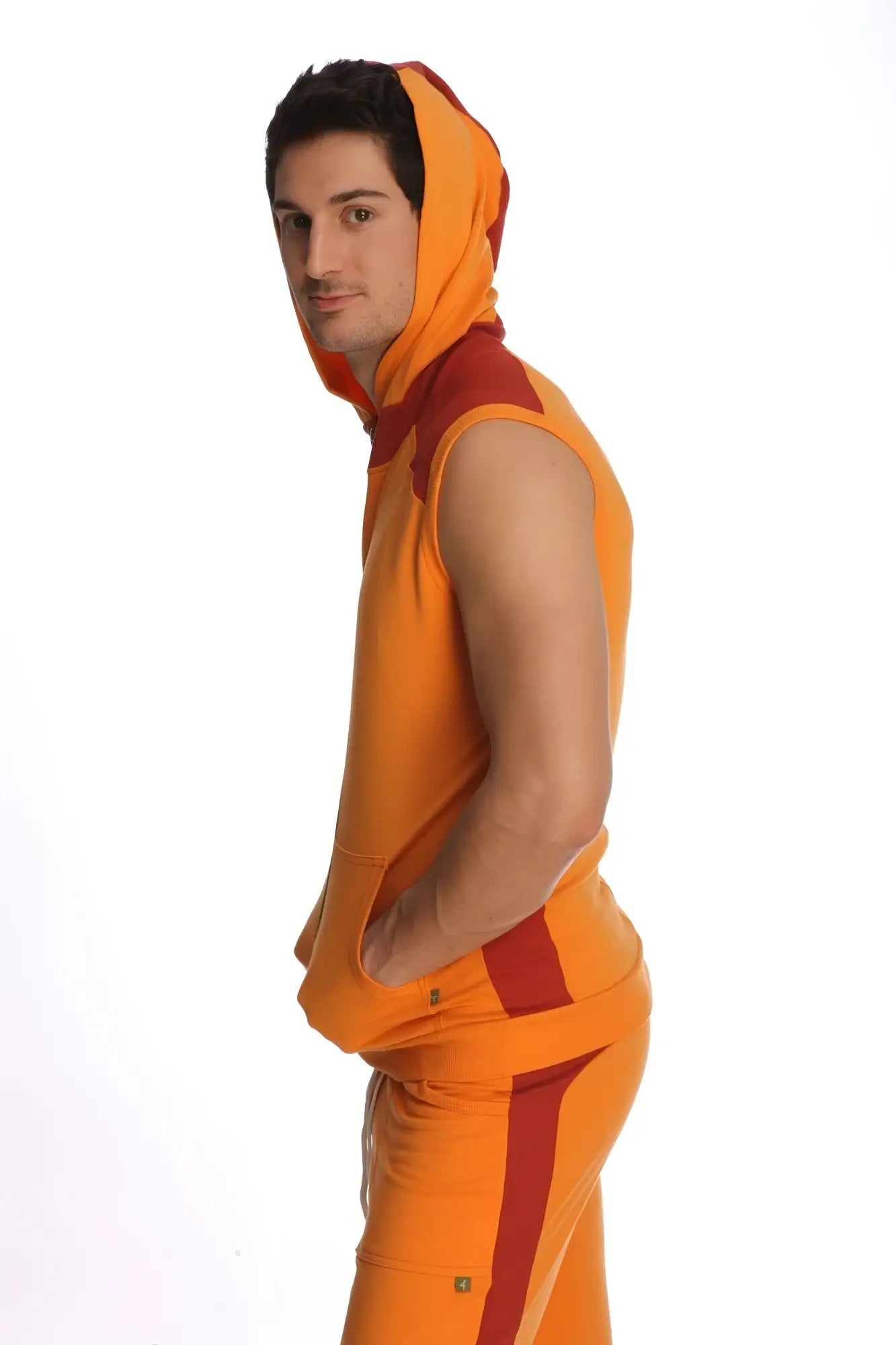 Sleeveless yoga hoodie in sun orange with bold orange and red color blocking on sides and hood trim