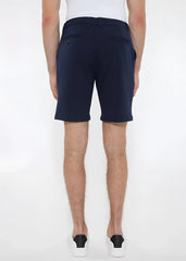 Navy blue solid stretch knit shorts with buttoned back pockets shown from the back in a tailored modern cut